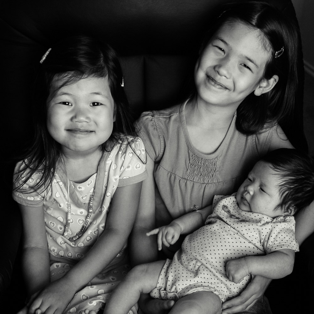 black and white of 3 sisters, with one a baby.