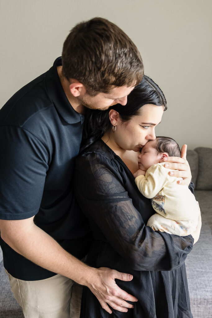 New parents holding their newborn during lifestyle newborn photography in Austin home