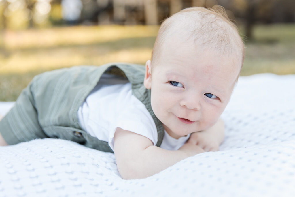 Awake newborn tummy time portrait during out-door newborn session in Austin TX