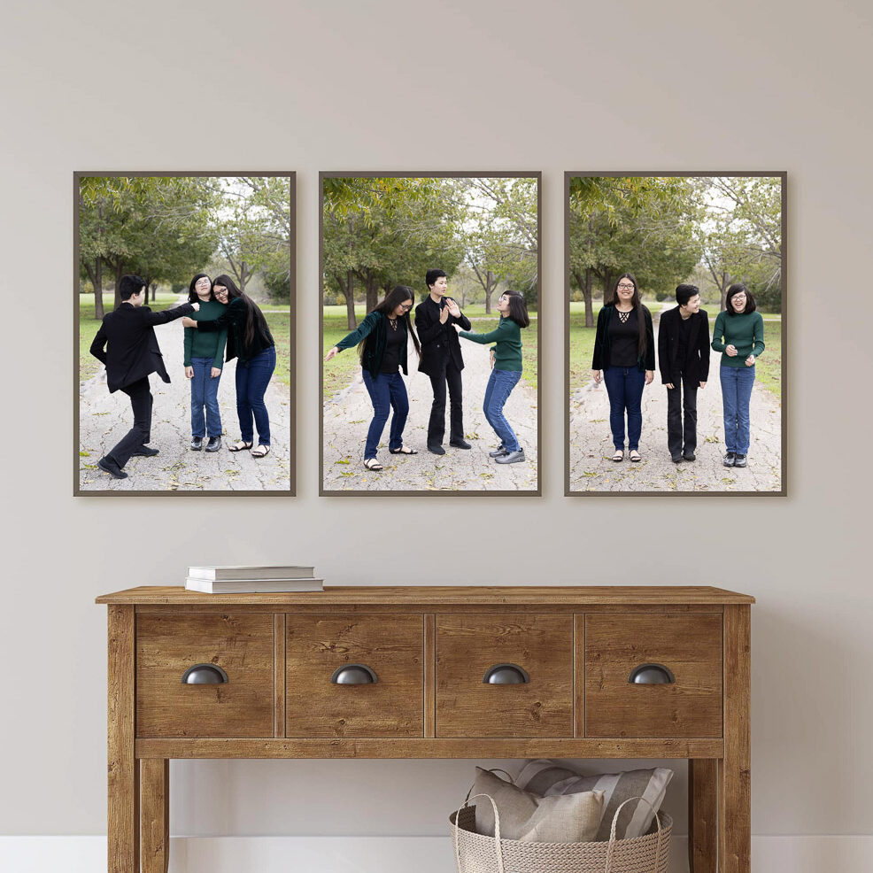 A triptych piece of wall art of 3 sisters being silly.